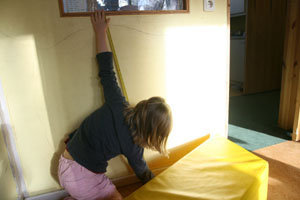 Mädchen misst mit Zollstock die Brüstungshöhe eines Fensters